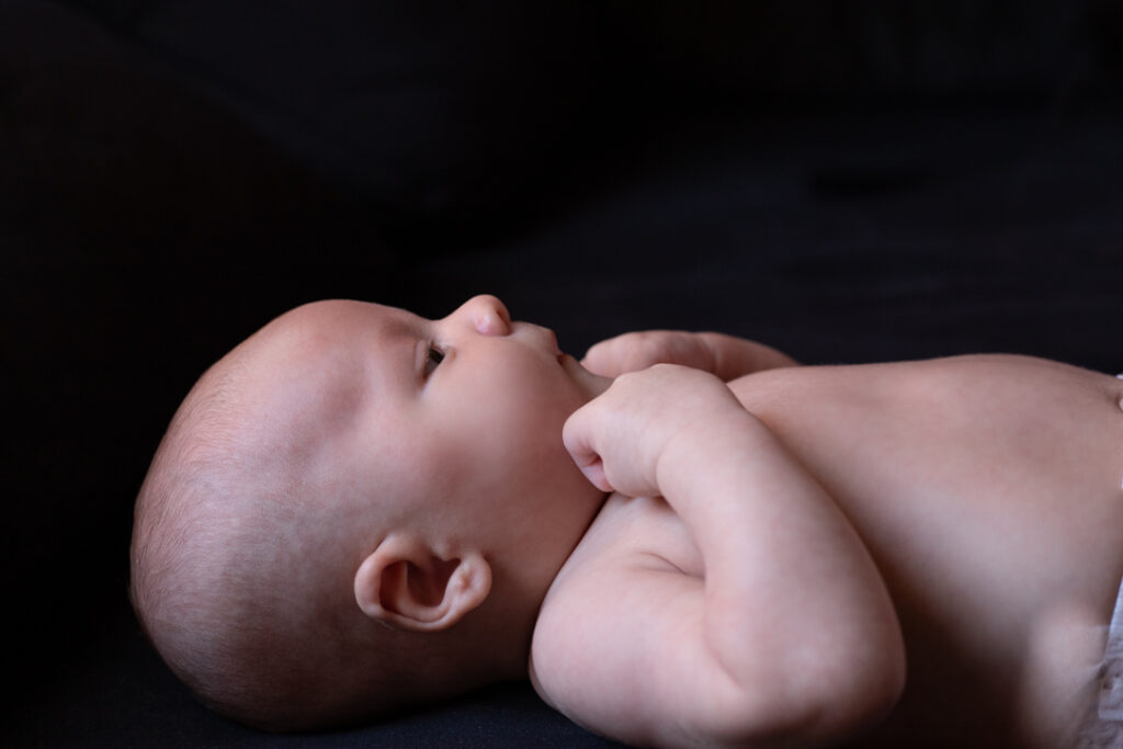 Fotografía de un bebé recién nacido Barcelona sobre un fondo negro