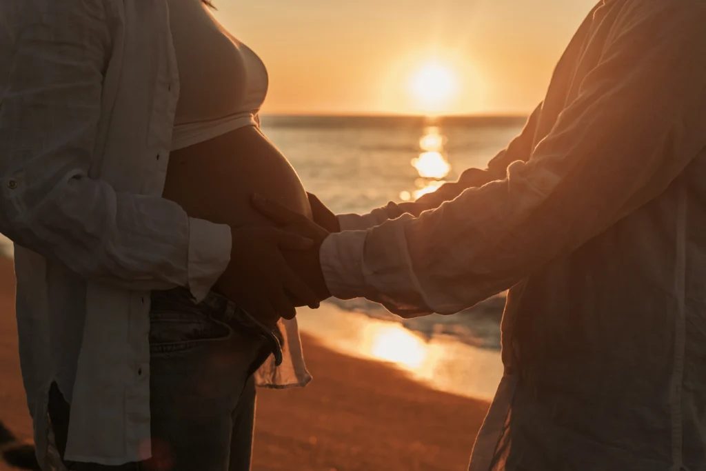 Fotografía de embarazo en pareja con luz de puesta de sol